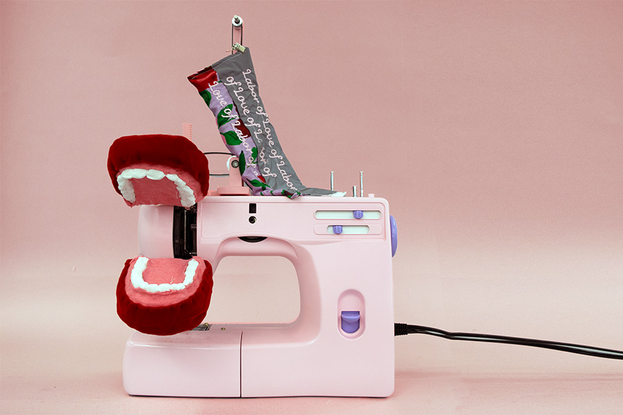 a pink sewing machine outfitted with a comically large mouth