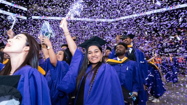 smiling grad waving pom pom with confetti falling