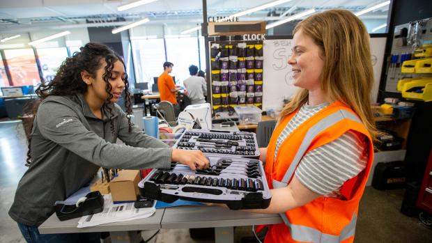 A student worker helping another student select the right tool