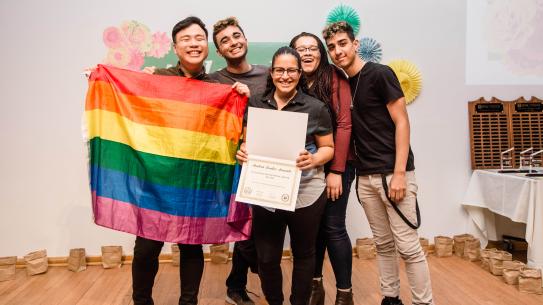 out in STEM student club holding rainbow flag