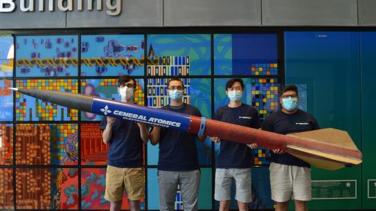 Students holding homemade rocket