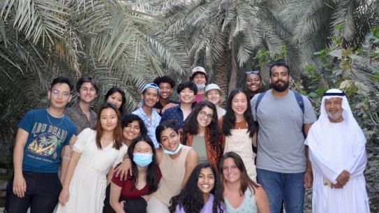 group shot of students in front of palm trees
