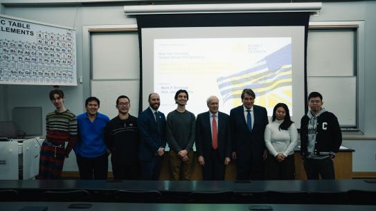 Attendees of the event in front of a projector screen