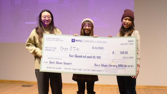 three female students holding oversized check for $500 