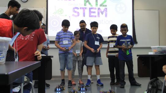 student participants in K12 STEM CrEST program group of young students controlling robotic cars