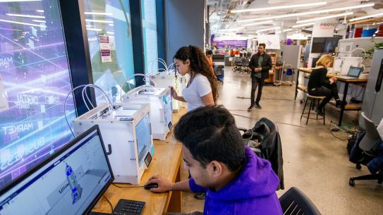 students using computer and 3d printer in makerspace