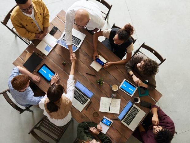 A group of people work together while sitting at a table.