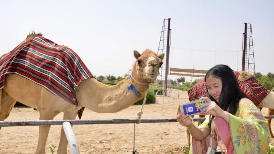 a student takes a selfie with a camel