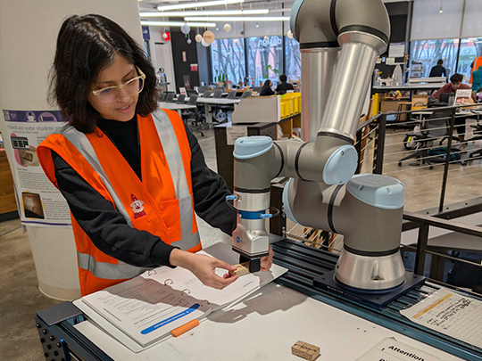 a student demonstrating how a robotic arm works
