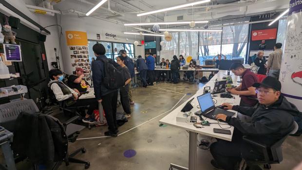 Students competing at the capstone showcasing their work on tables in a U shape