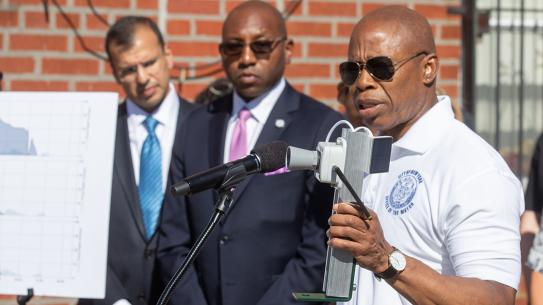 NYC Mayor Eric Adams with FloodNet sensor speaking at microphone