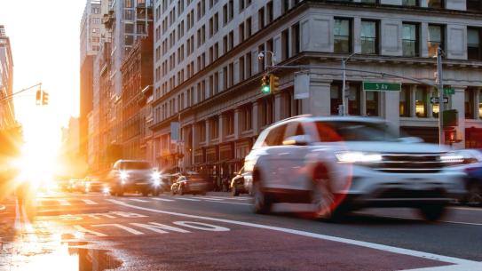 a street in Manhattan with cars driving by