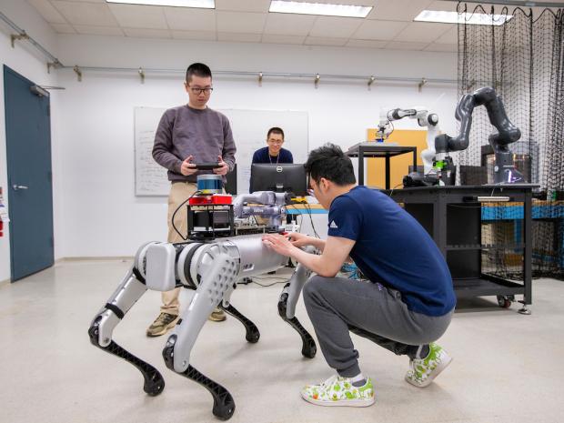 two students in a lab working on a robotic dog